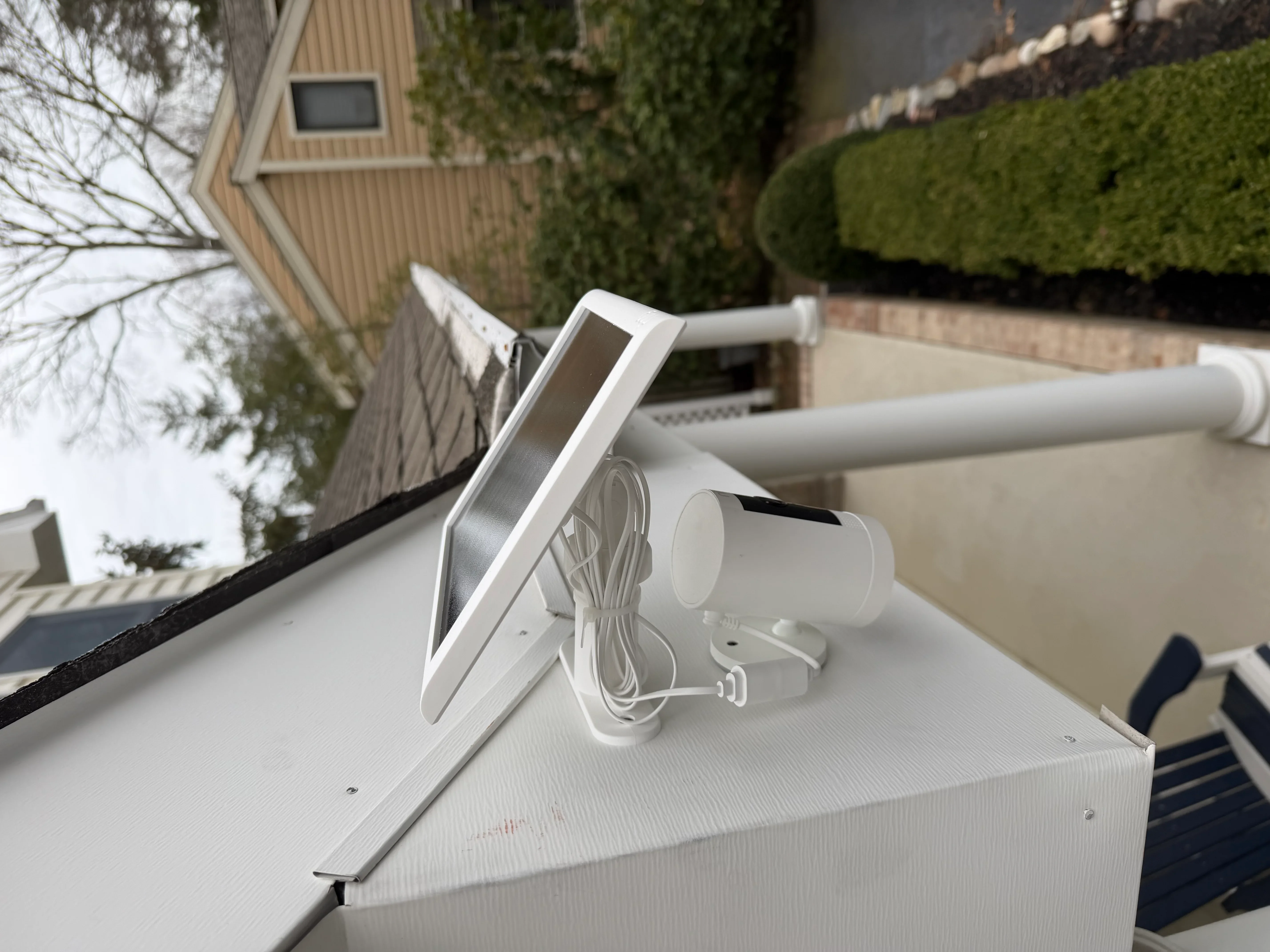 White aluminum gutter system with downspout and brackets installed on residential roofline