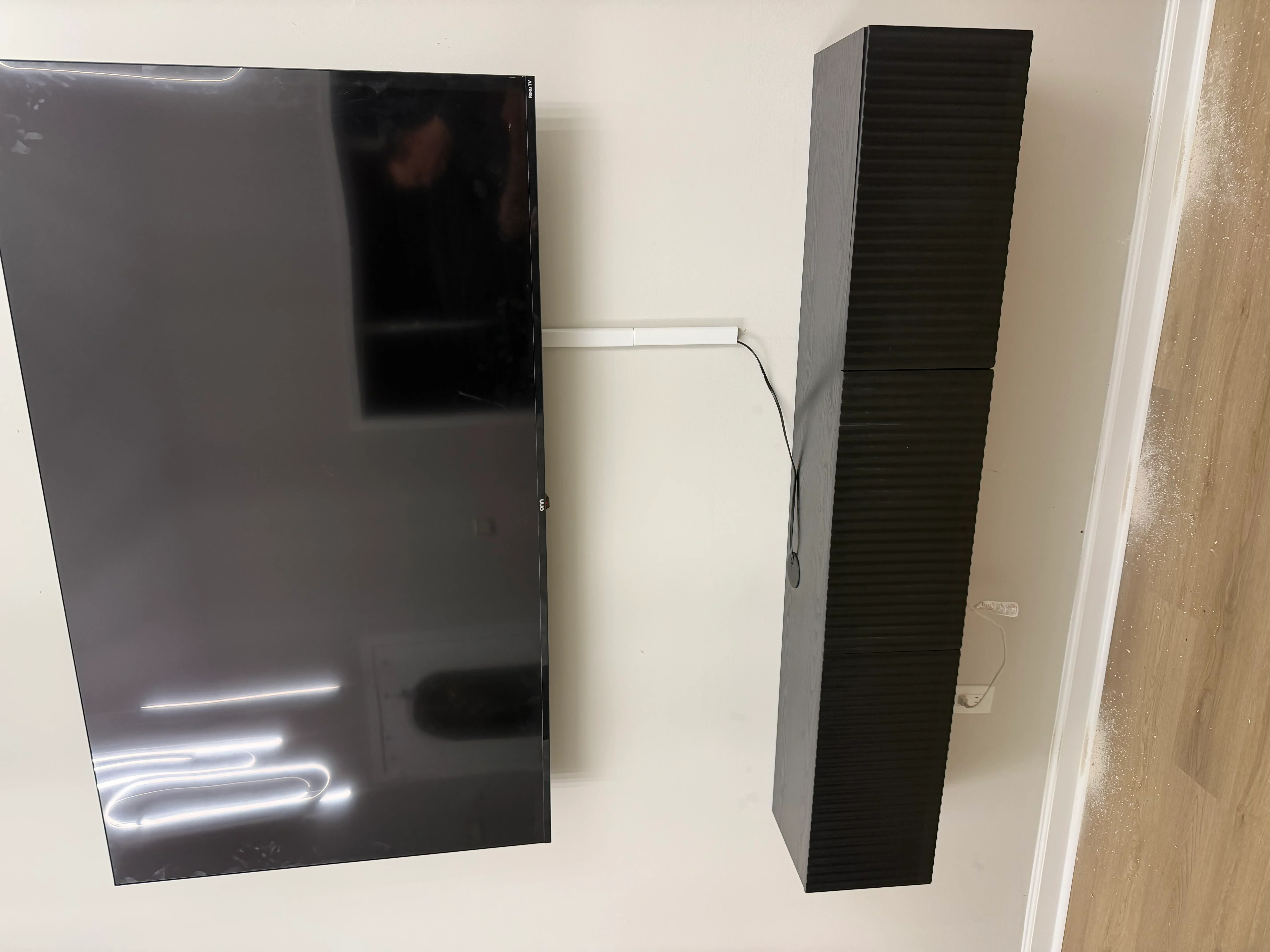 Wall-mounted TV with speaker installation and cable management conduit