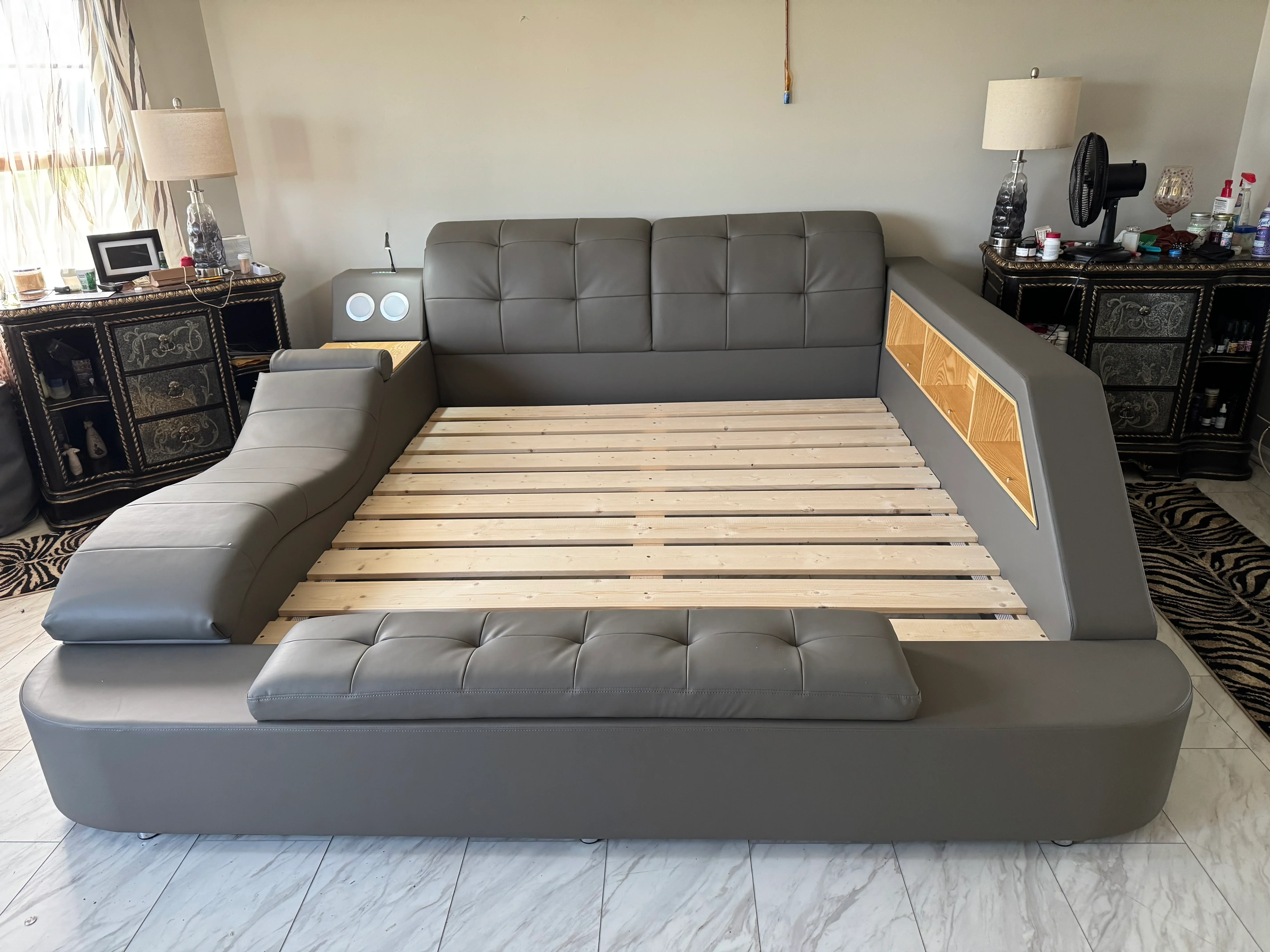Gray upholstered bed frame with wood slats, padded headboard, and wood inlay panels