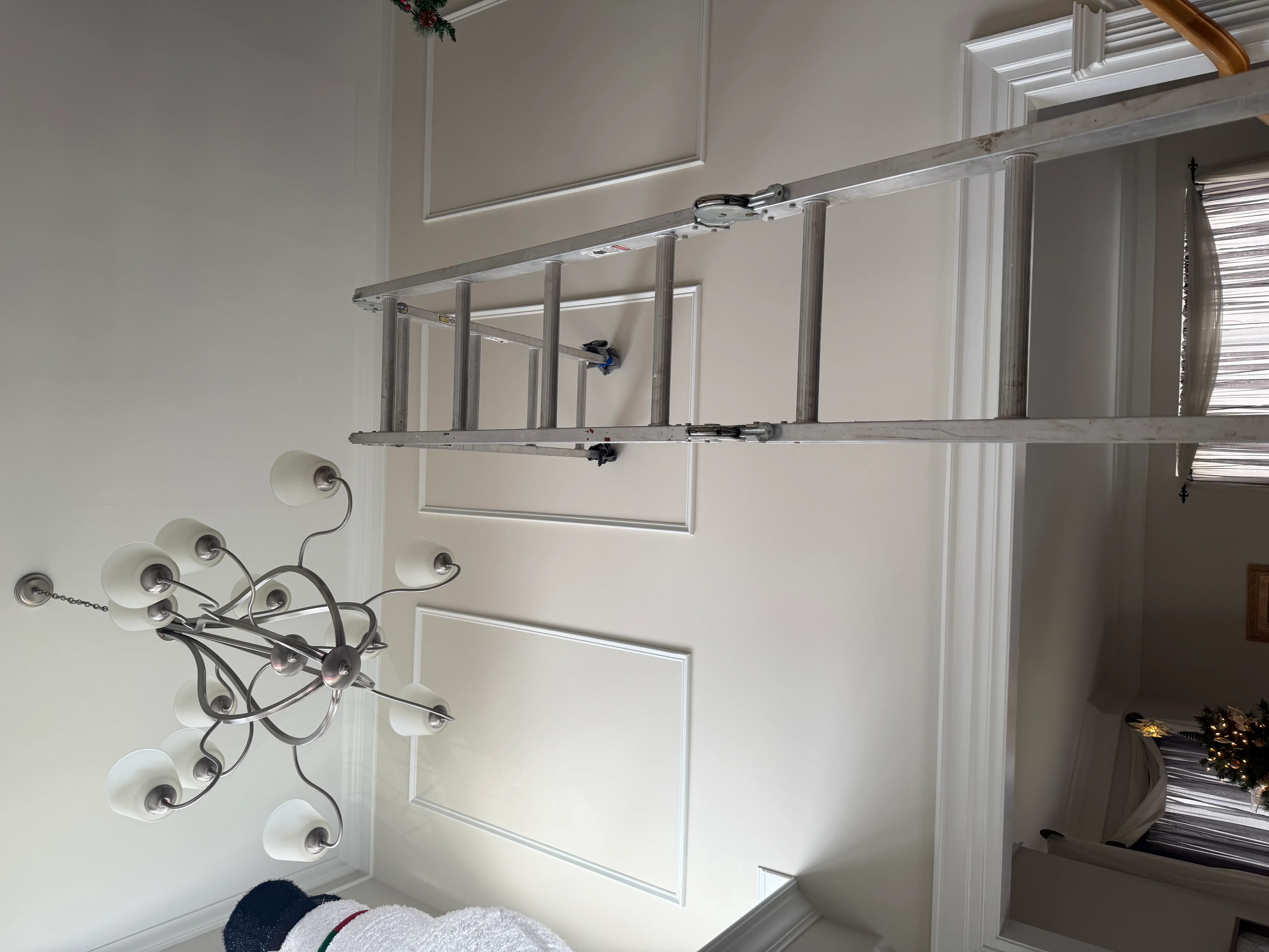 Aluminum shelving system with wall sconce installation in white bathroom with wainscoting