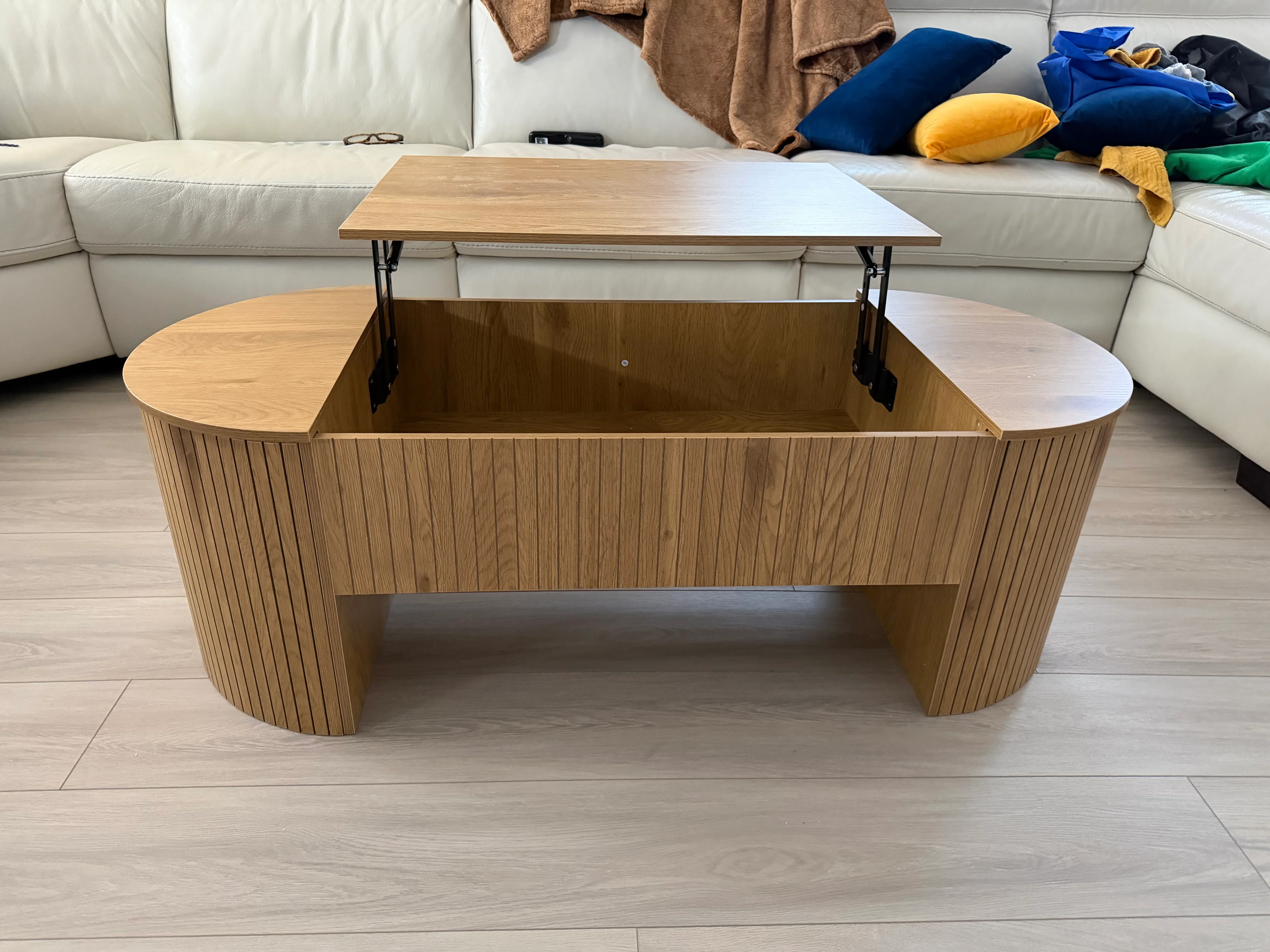 Wooden lift-top coffee table with vertical slat paneling, open shelf storage, and hydraulic lift mechanism