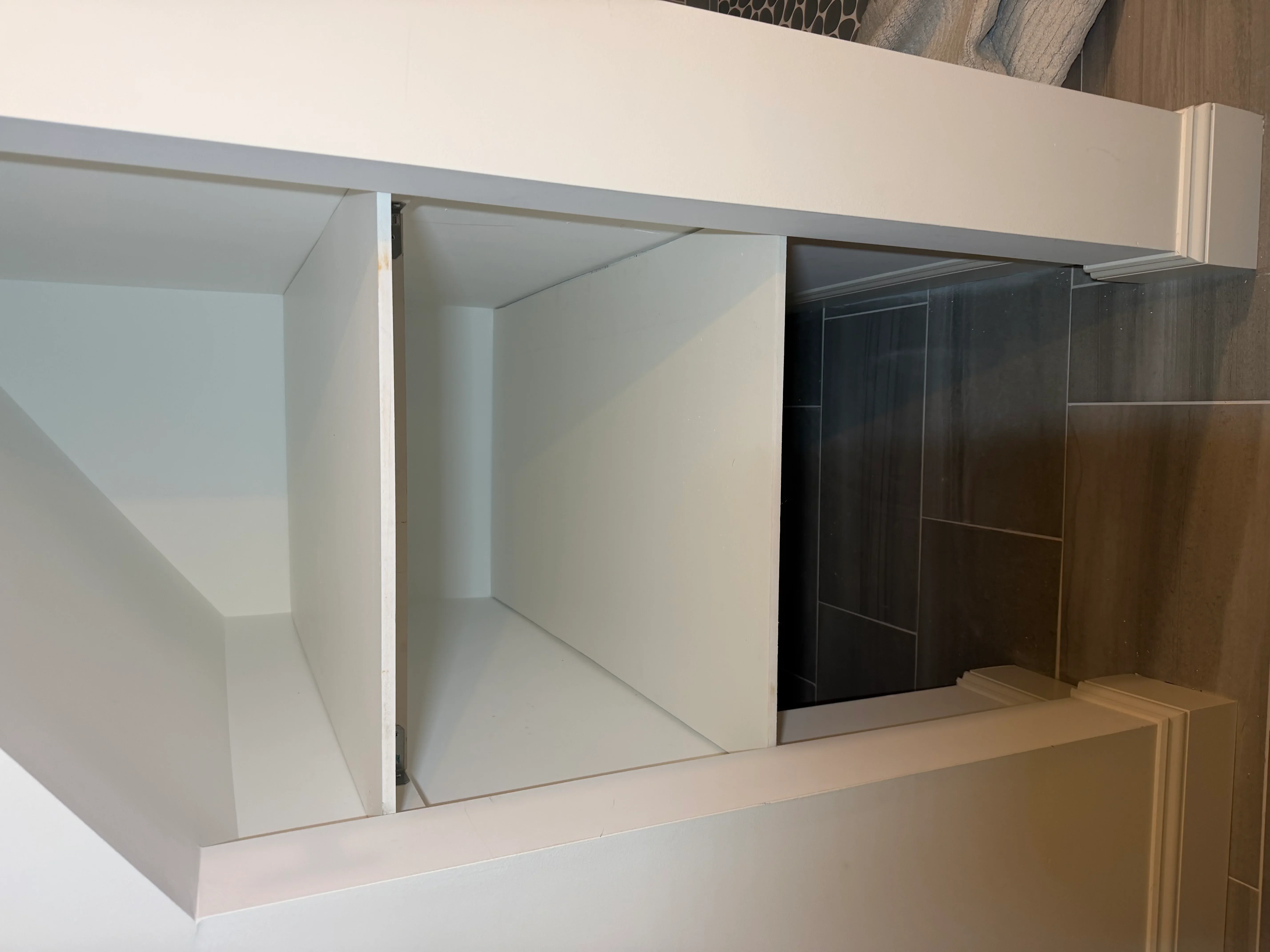 Built-in white cabinets with dark wood sliding glass doors and interior shelving