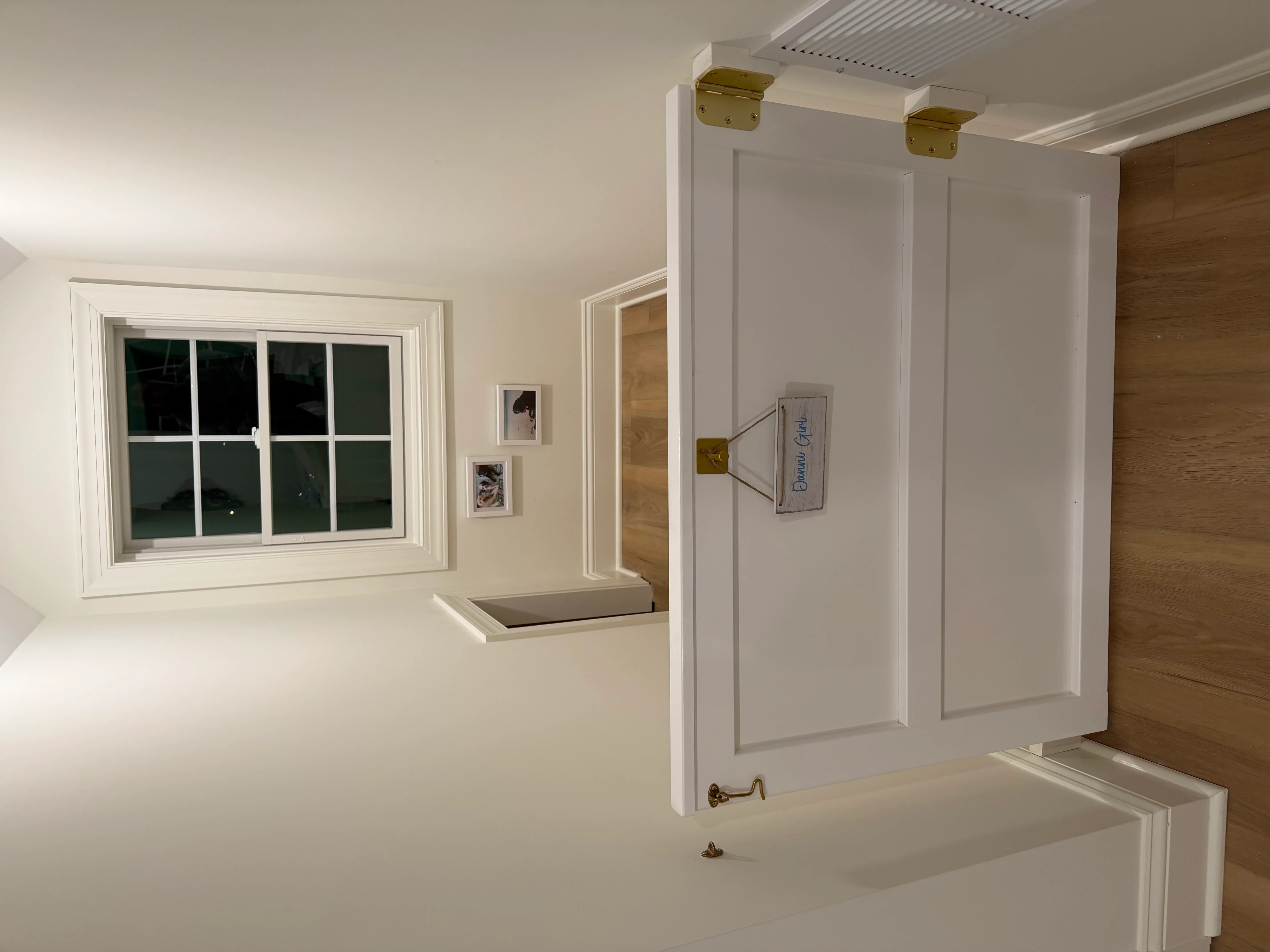 Frameless glass shower enclosure with brass hinges and hardware in white bathroom