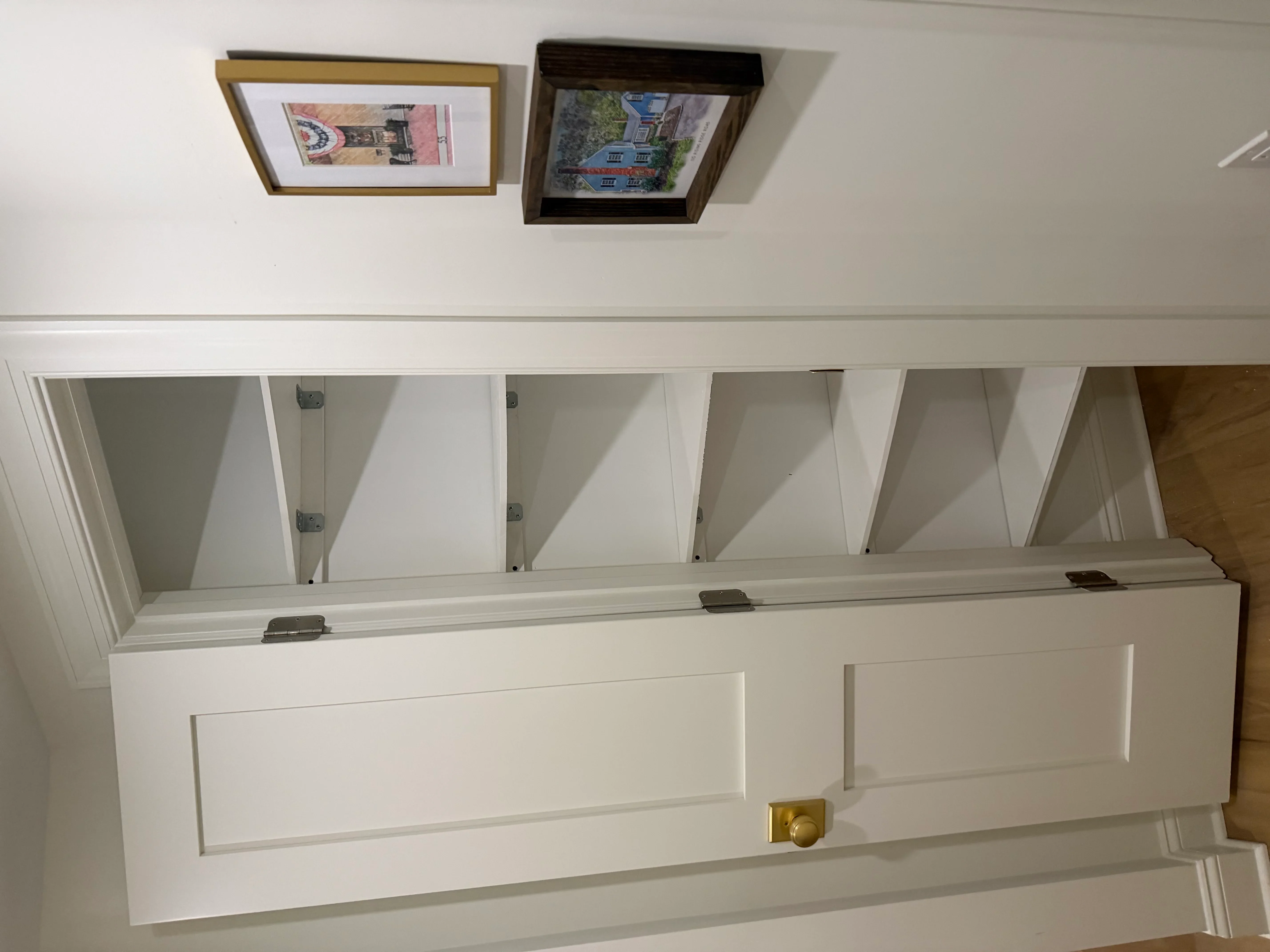 White built-in cabinetry with glass display compartments and brass hardware