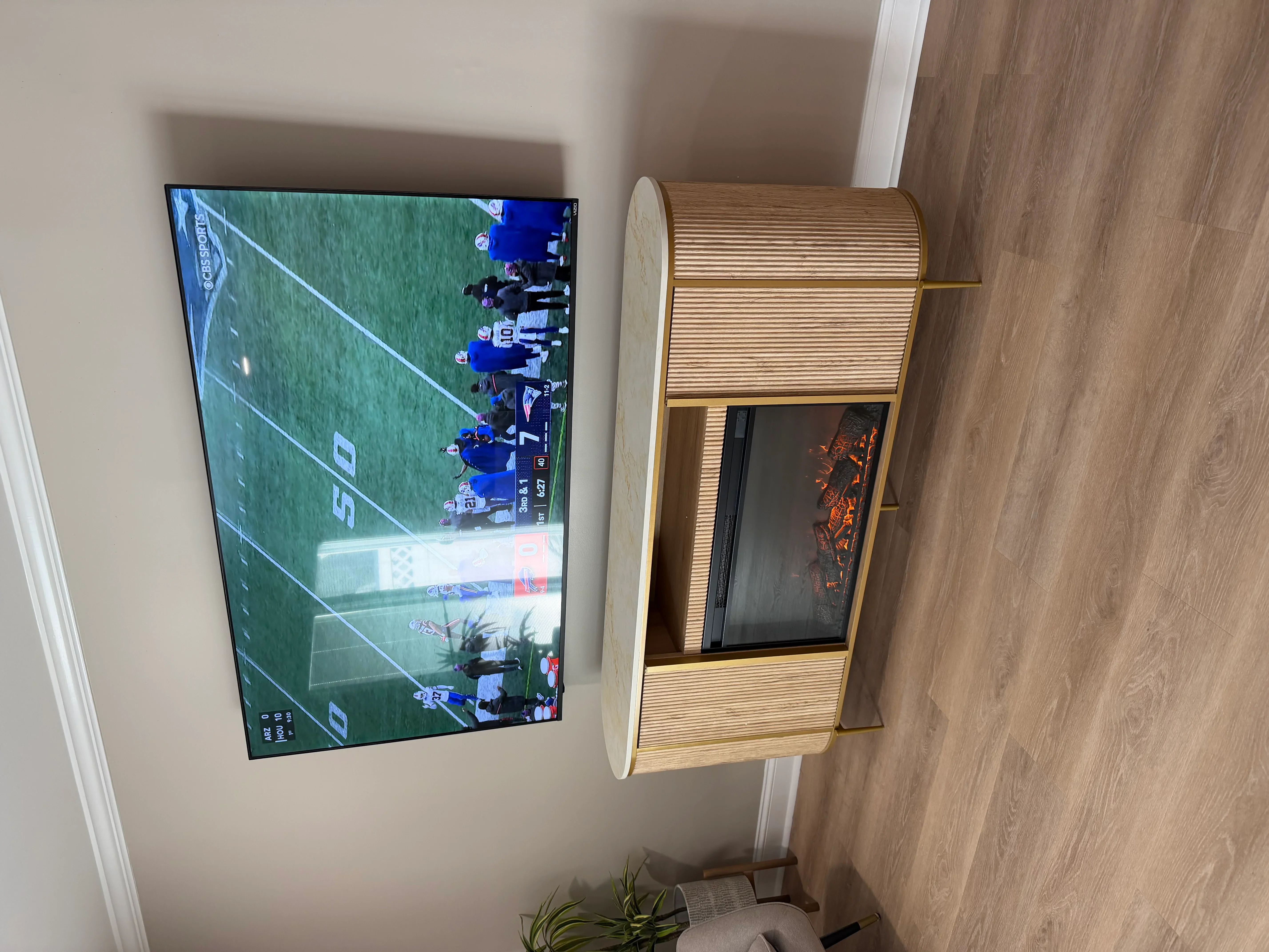 Wall-mounted flat-screen TV with custom wood slat enclosure and rolling door cabinet