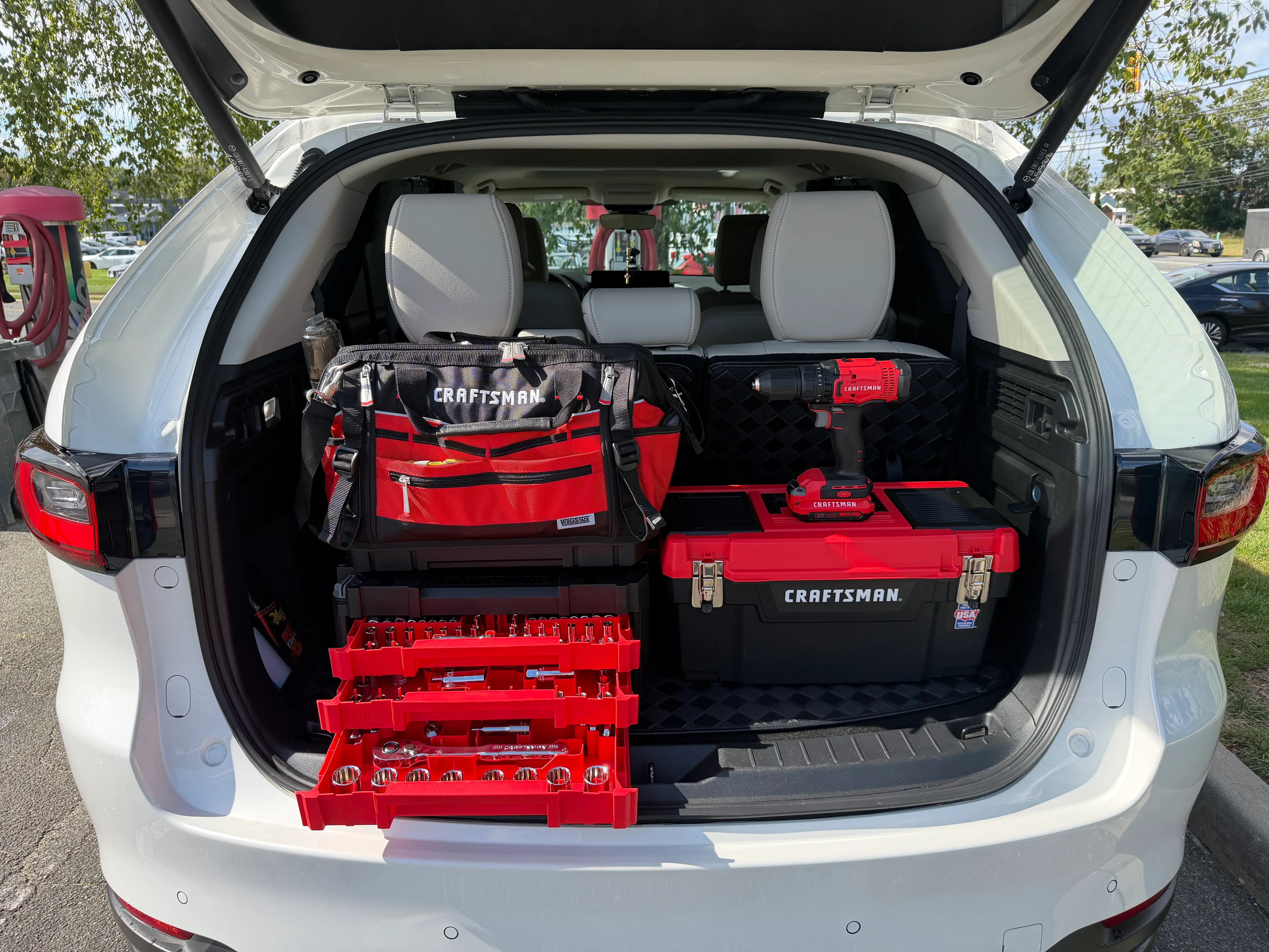 Vehicle cargo area with organized red Craftsman toolboxes, tool bags, and storage containers